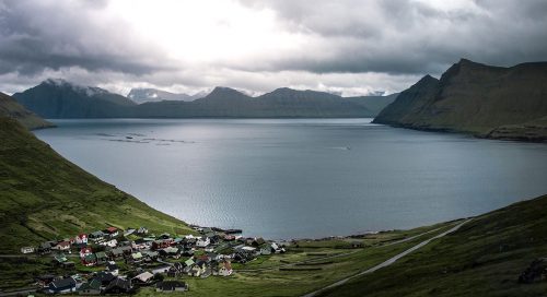 Foto de un pequeño pueblo a la orilla de un lago situado en un valle entre montañas