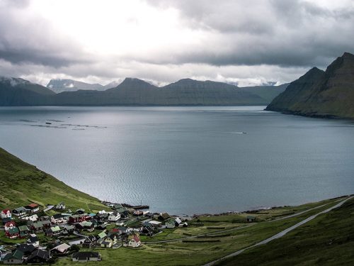 Foto de un pequeño pueblo a la orilla de un lago situado en un valle entre montañas