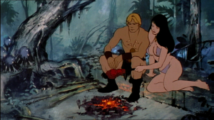 Captura de pantalla de la película animada de 1983: Fire and Ice, mostrando un hombre y una mujer primitivos sentados junto a una fogata