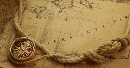 Foto de un viejo mapa con una brújula y una soga